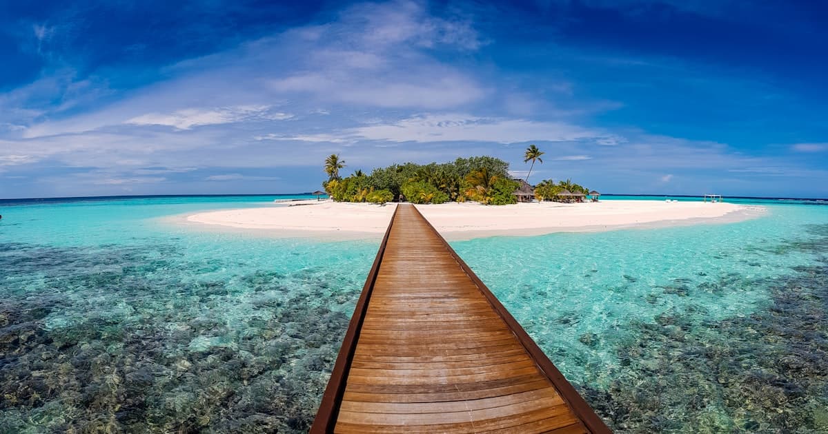 Tropical Philippine island with bright turquoise water and a wooden boardwalk leading to shore